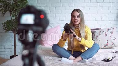 搞笑女博主录制视频.. 女孩美容博主坐在床上，给你的博客写视频。